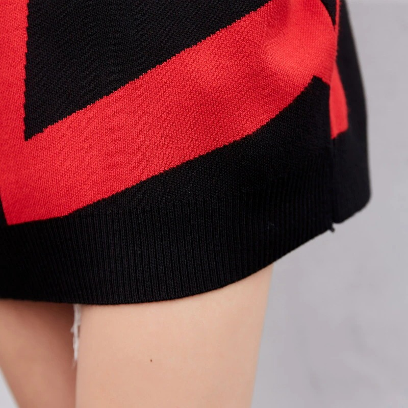 Close-up of a women's oversized black knitting hoodie with a bold red geometric design.