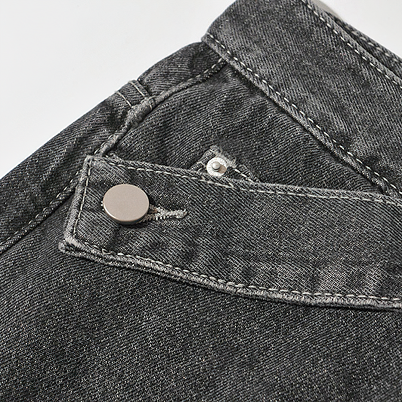 Close-up of stylish denim jeans featuring a metal button and detailed stitching, perfect for trendy outfits.