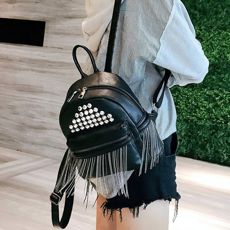 Trendy women's mini black backpack with rivets and fringe, perfect for casual outfits and everyday use.