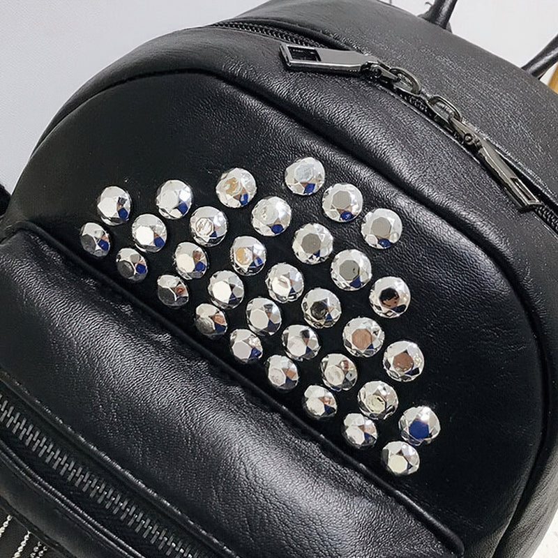 Mini black backpack with decorative silver rivets, stylish PU leather bag perfect for casual outfits.