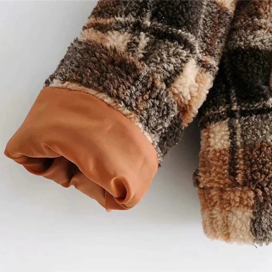 Close-up of the cuff of a women's plaid lamb wool jacket in cozy brown tones, perfect for chilly days.