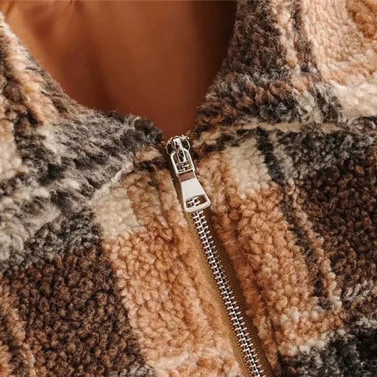 Close-up of a stylish women's plaid lamb wool jacket featuring a cozy fleece texture and vintage zipper detail.