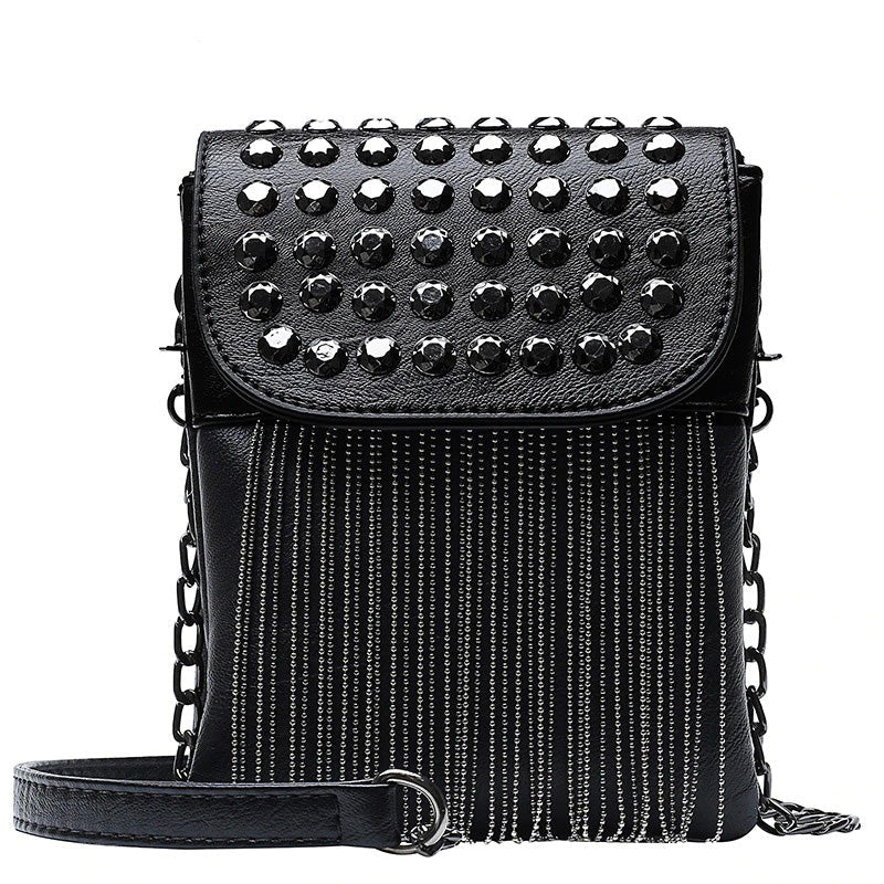 Trendy black women's shoulder bag with decorative chain and fringe, featuring striking studs and a fierce look.