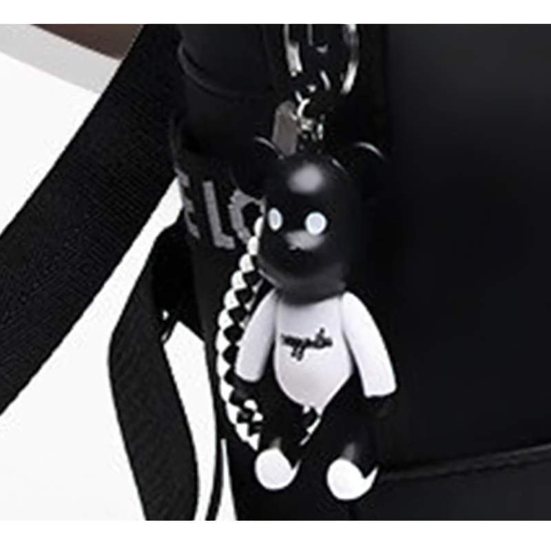 Keychain featuring a cute bear charm hanging from a stylish black PU leather backpack.