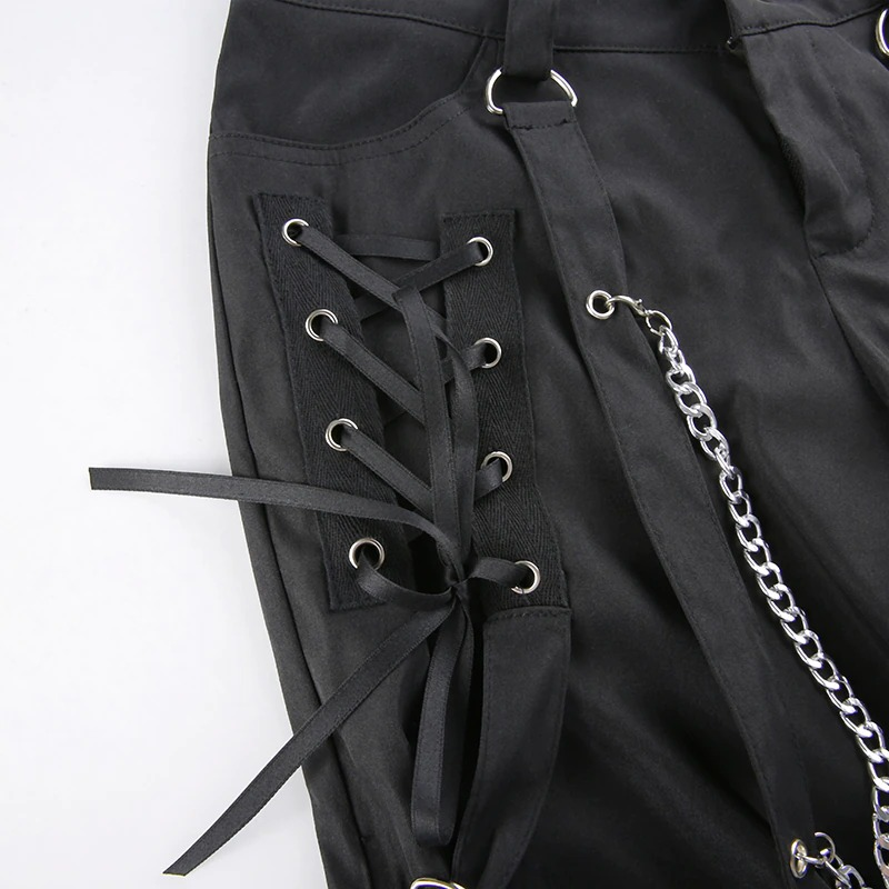 Detailed view of black women's wide leg cargo pants featuring lace-up design and silver chain accents in punk style.