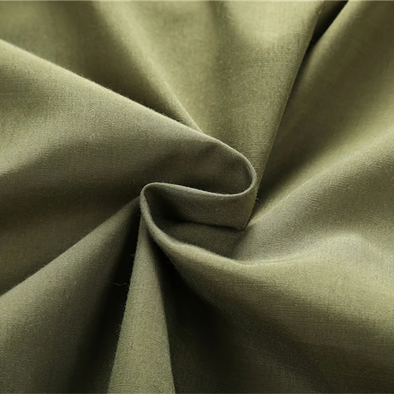 Close-up of olive green cotton fabric, showcasing texture for stylish military jackets and casual attire.