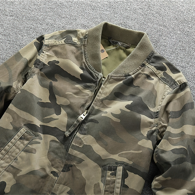 Stylish men's camouflage zip-up denim jacket displayed on a textured surface, perfect for casual wear and military-inspired fashion.