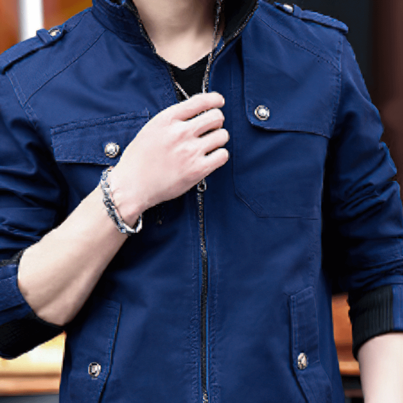 Stylish male model wearing a blue military zipper jacket with pockets and a stand collar, showcasing a modern cut.