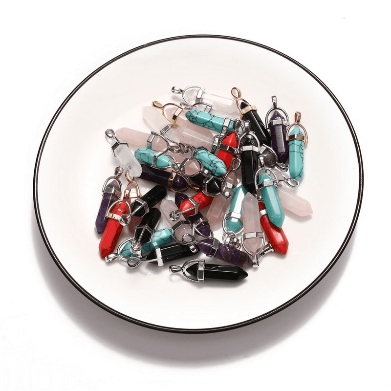 Colorful hexagonal stone pendants in a white bowl, perfect for gothic-style jewelry making.