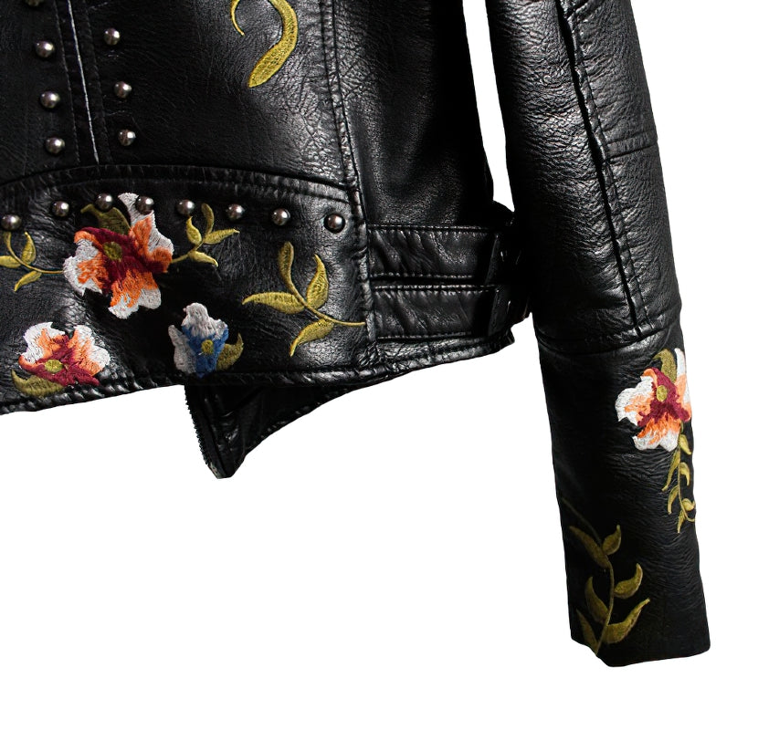 Black faux leather women's motorcycle jacket with colorful floral embroidery and studs, stylish outerwear for fall and winter.