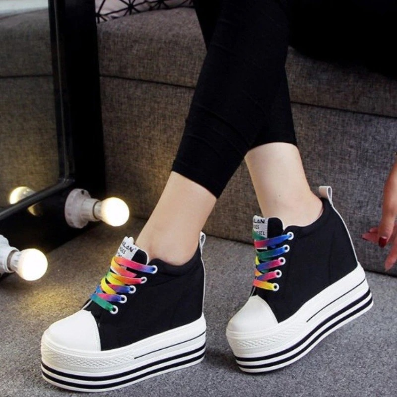 Stylish female canvas platform sneakers with colorful laces, perfect for any outfit, shown on a model's feet.