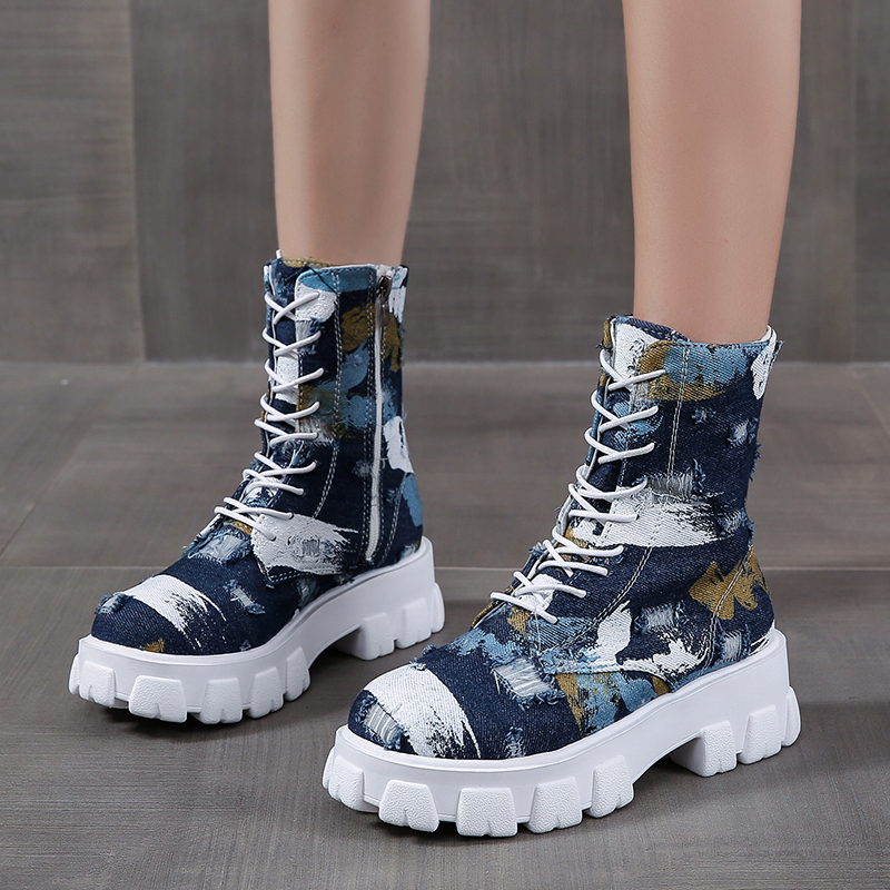 Trendy women's combat boots in alternative style with artistic print and chunky white sole.