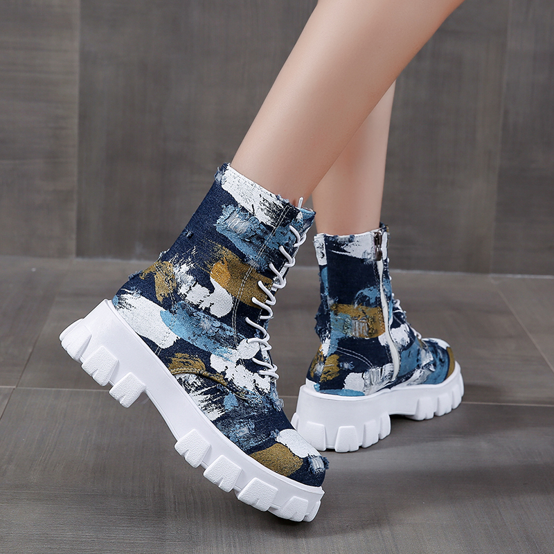 Trendy female combat boots in abstract print with laces and side zipper, perfect for a rocker girl outfit.