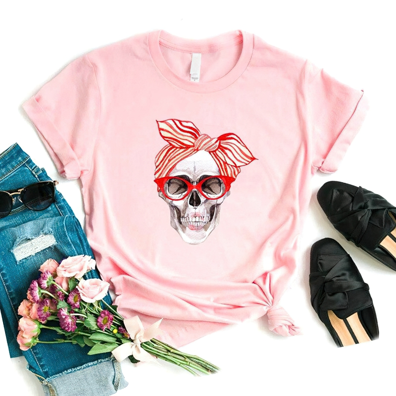 Stylish pink skull print t-shirt for women, paired with jeans, flowers, sunglasses, and chic black shoes.