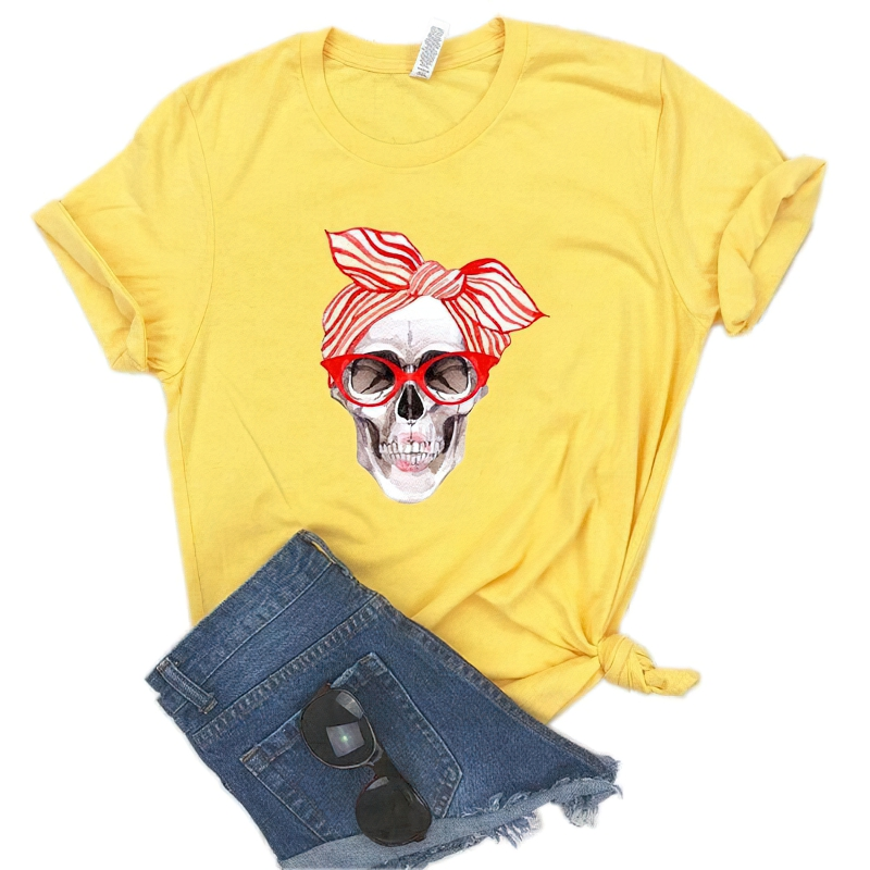 Yellow women's t-shirt featuring a stylish skull print with sunglasses and a headband, paired with denim shorts.