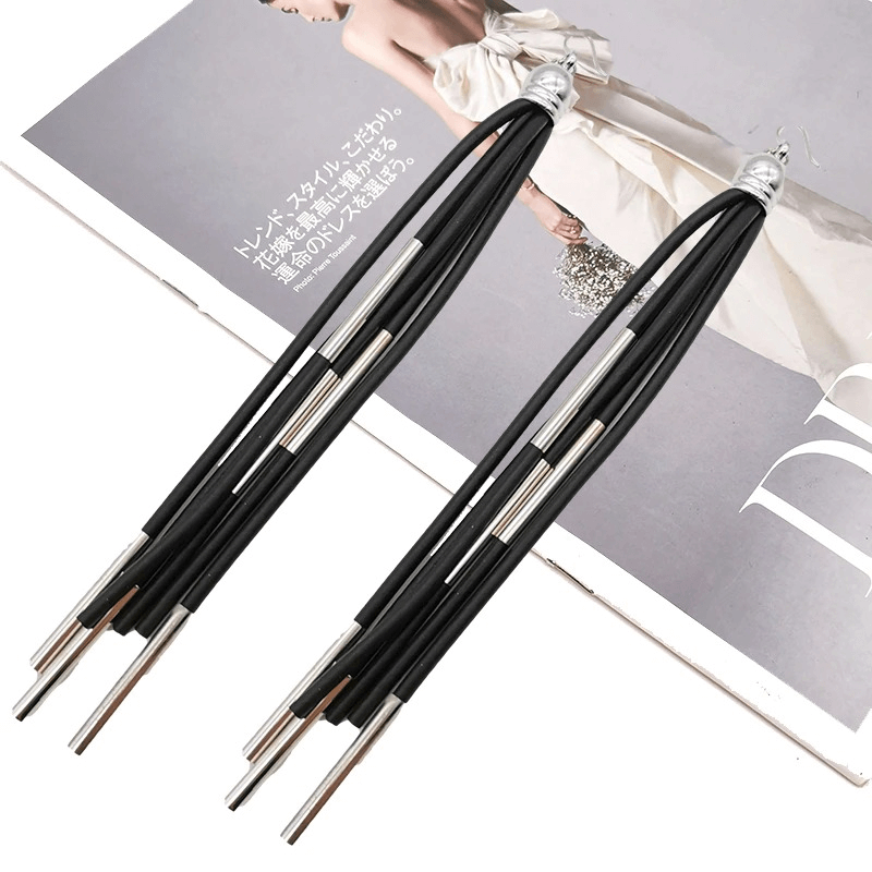 Stylish handmade punk long black rubber earrings on a fashion magazine, perfect accessory for edgy outfits.