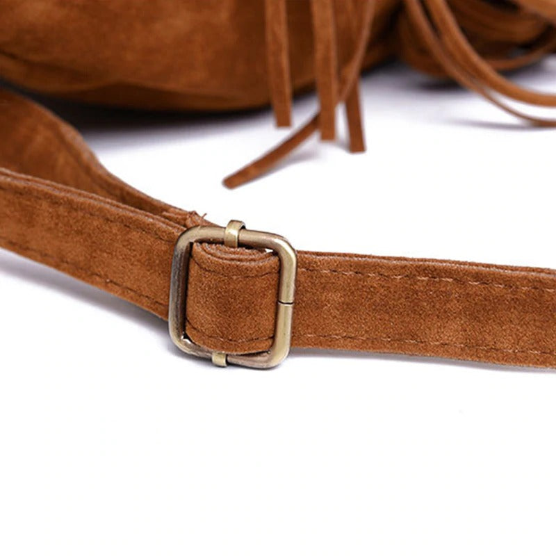 Close-up of brown suede backpack strap with stylish metal buckle for trendy women alternative fashion.