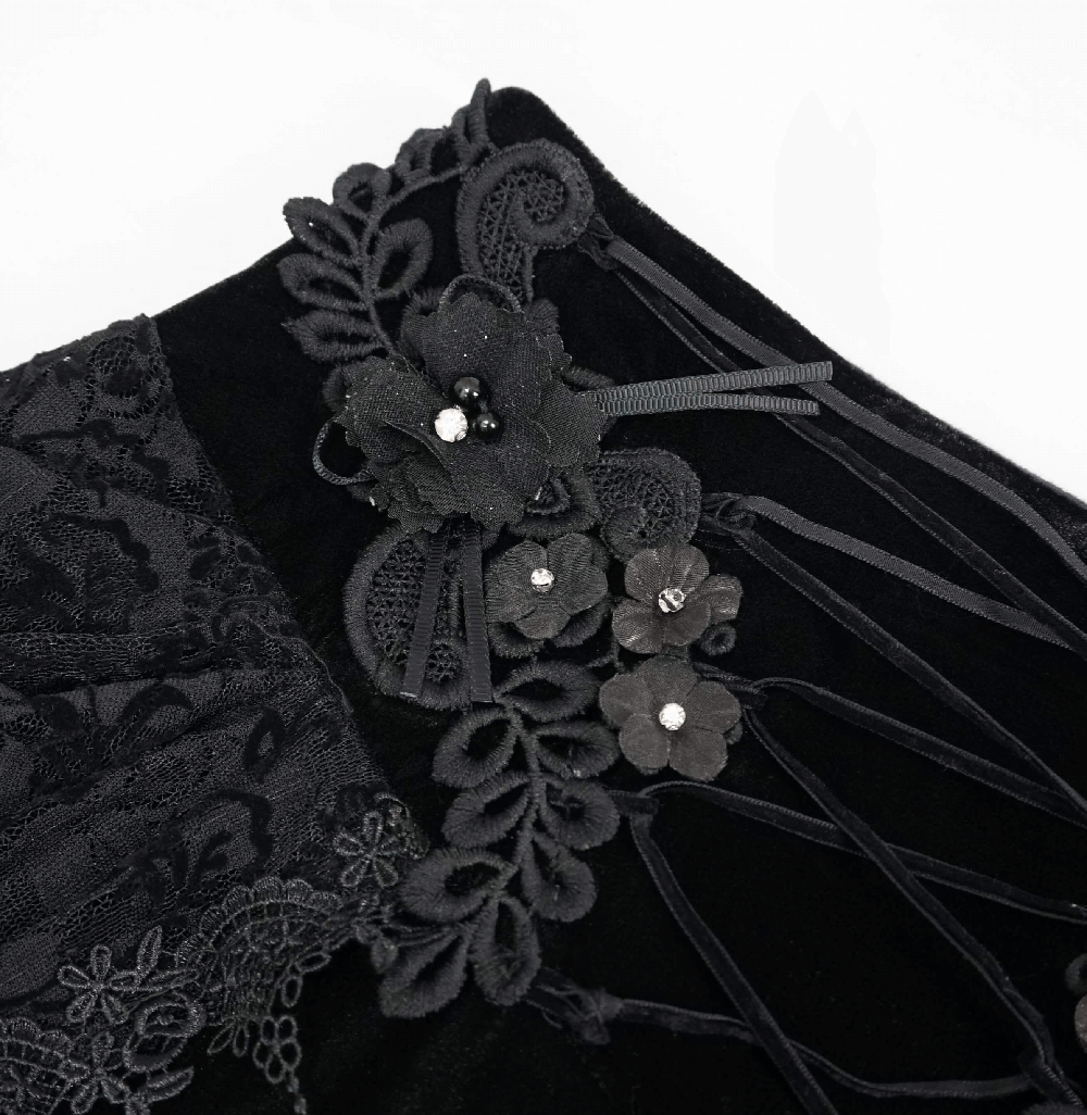 Close-up of black velvet skirt with lace and 3D flower embellishments for vintage gothic style.