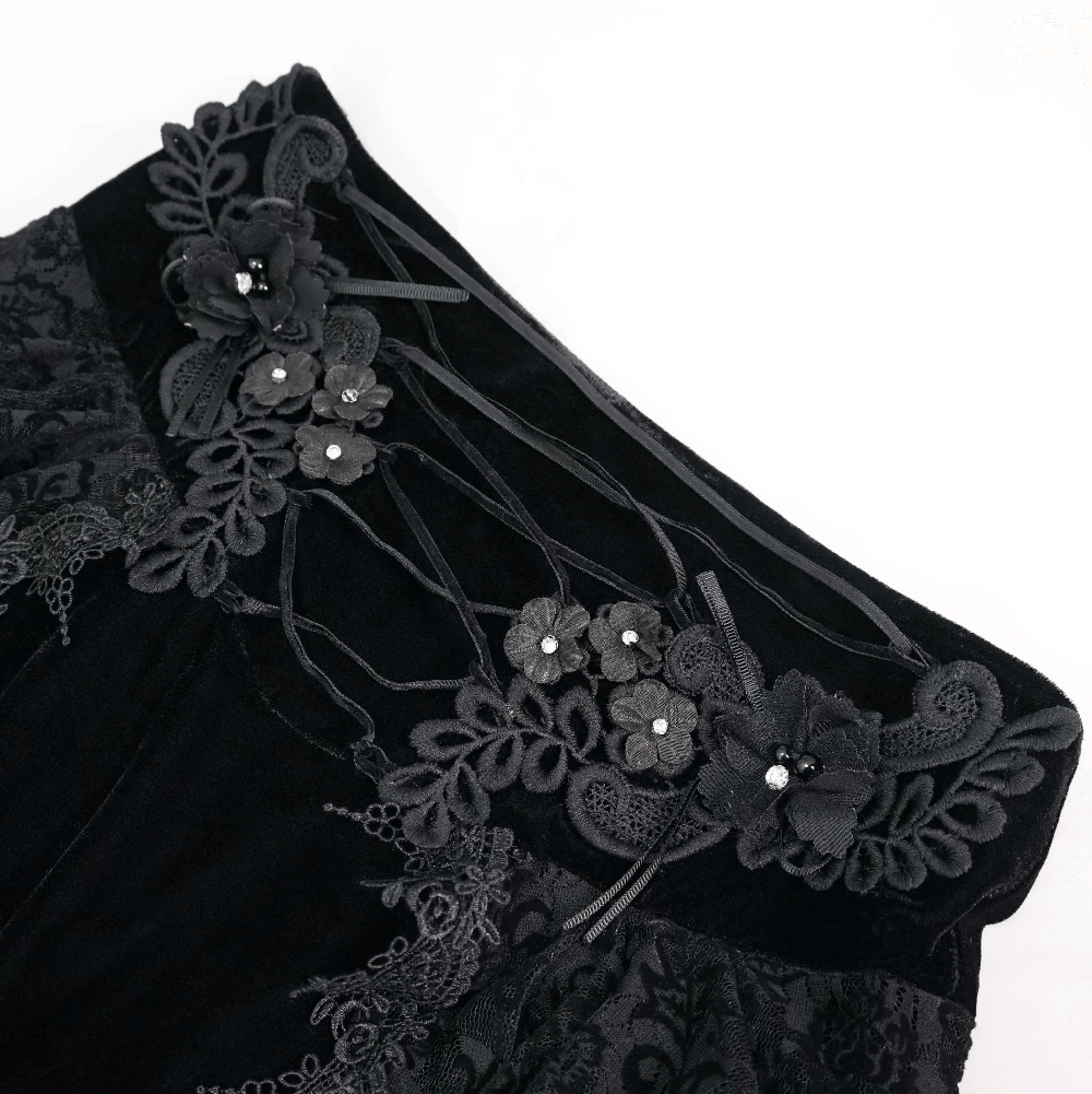 Close-up of black velvet vintage gothic skirt featuring lace and 3D floral embellishments.