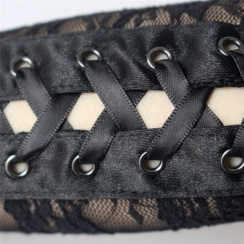 Close-up of black lace fingerless gloves showcasing intricate ribbon and rivet details, perfect for gothic fashion.