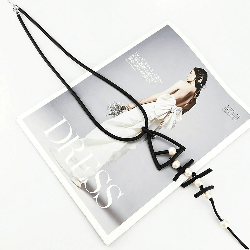 Gothic rubber fish bone pendant necklace on fashion magazine, featuring elegant pearls and stylish design.