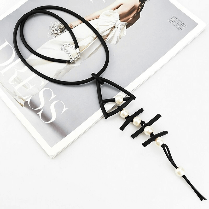 Gothic fish bone pendant necklace with rubber material and elegant pearls showcased on a fashion magazine.