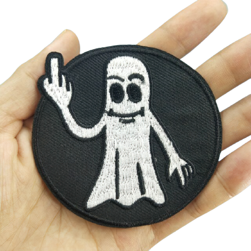 Stylish flip off ghost patch held in hand, unisex gothic fashion accessory for clothes decoration.