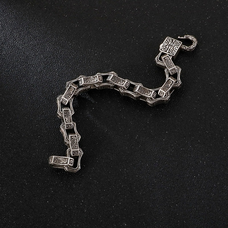 Vintage engraved square bracelet on dark background, men's punk stainless steel cuff chain style.