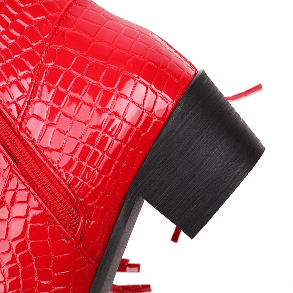 Close-up of red vintage knee-high boot with tassels and textured finish, showcasing stylish zipper detail.