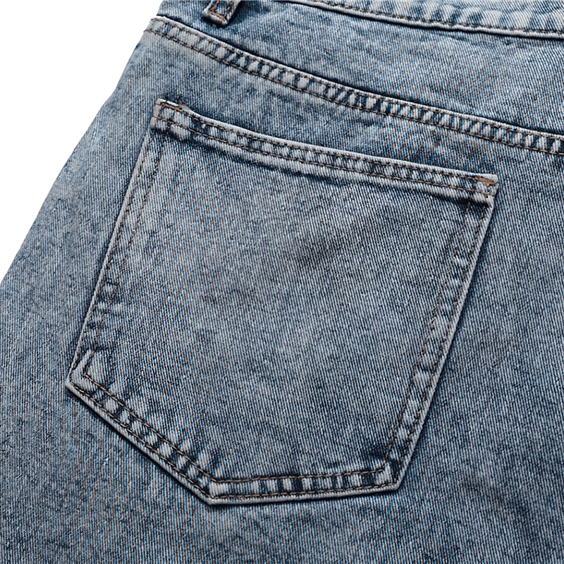 Close-up of the back pocket of men's patchwork denim shorts, showcasing alternative style and loose fit.