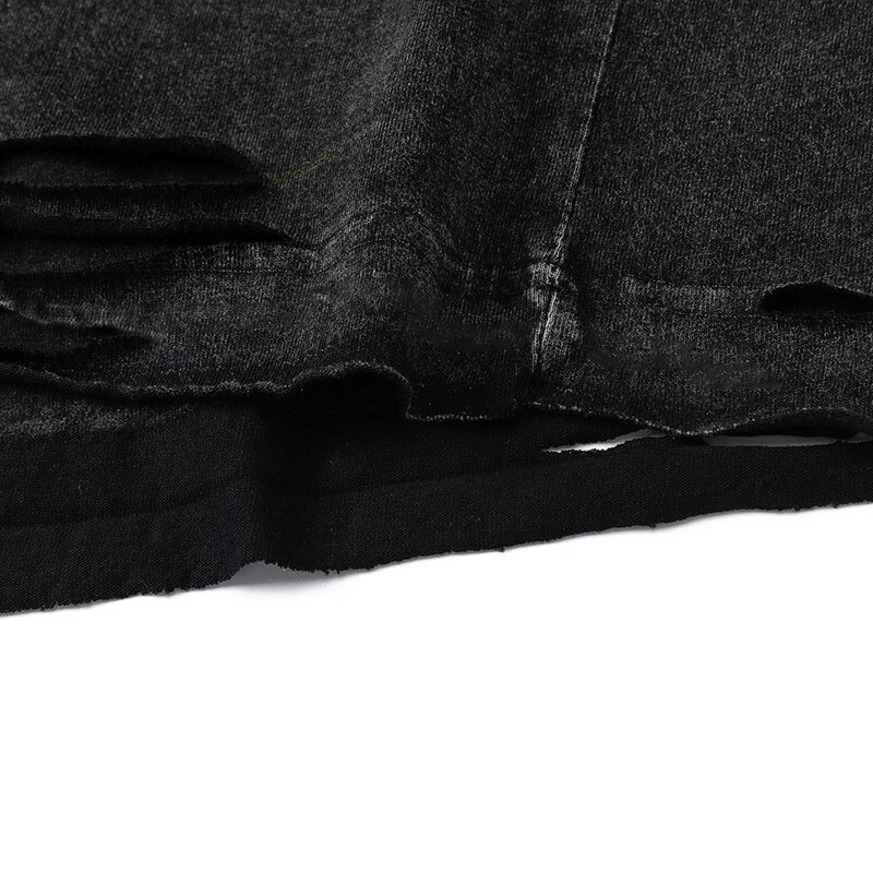 Close-up of a ripped black gothic tank top, showcasing trendy distressed details for men's fashion.