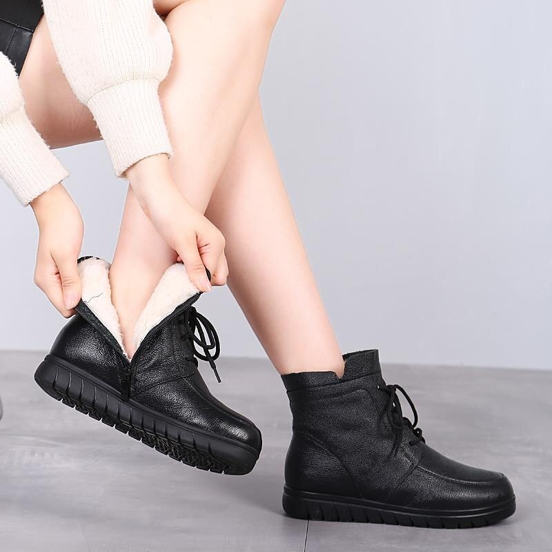 Stylish women's genuine leather ankle boots being worn, featuring a cozy lining and lace-up design for comfort.