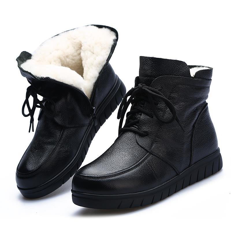 Stylish women's black leather ankle boots with lace-up design and cozy fur lining, perfect for casual winter wear.