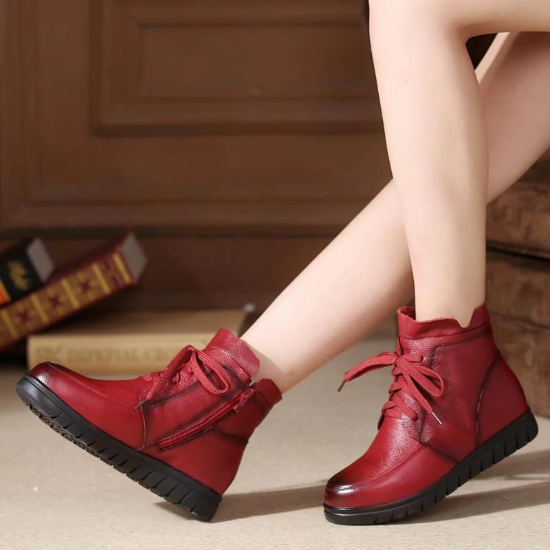 Stylish women's genuine leather ankle boots in red, featuring lace-up design and comfortable low sole for casual wear.