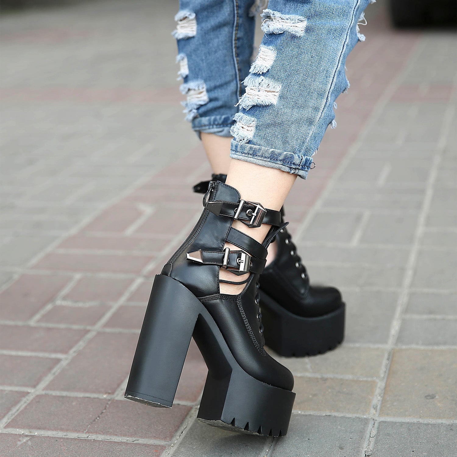 Stunning black platform ankle boots with buckles, worn with distressed jeans for a rocker chic style.