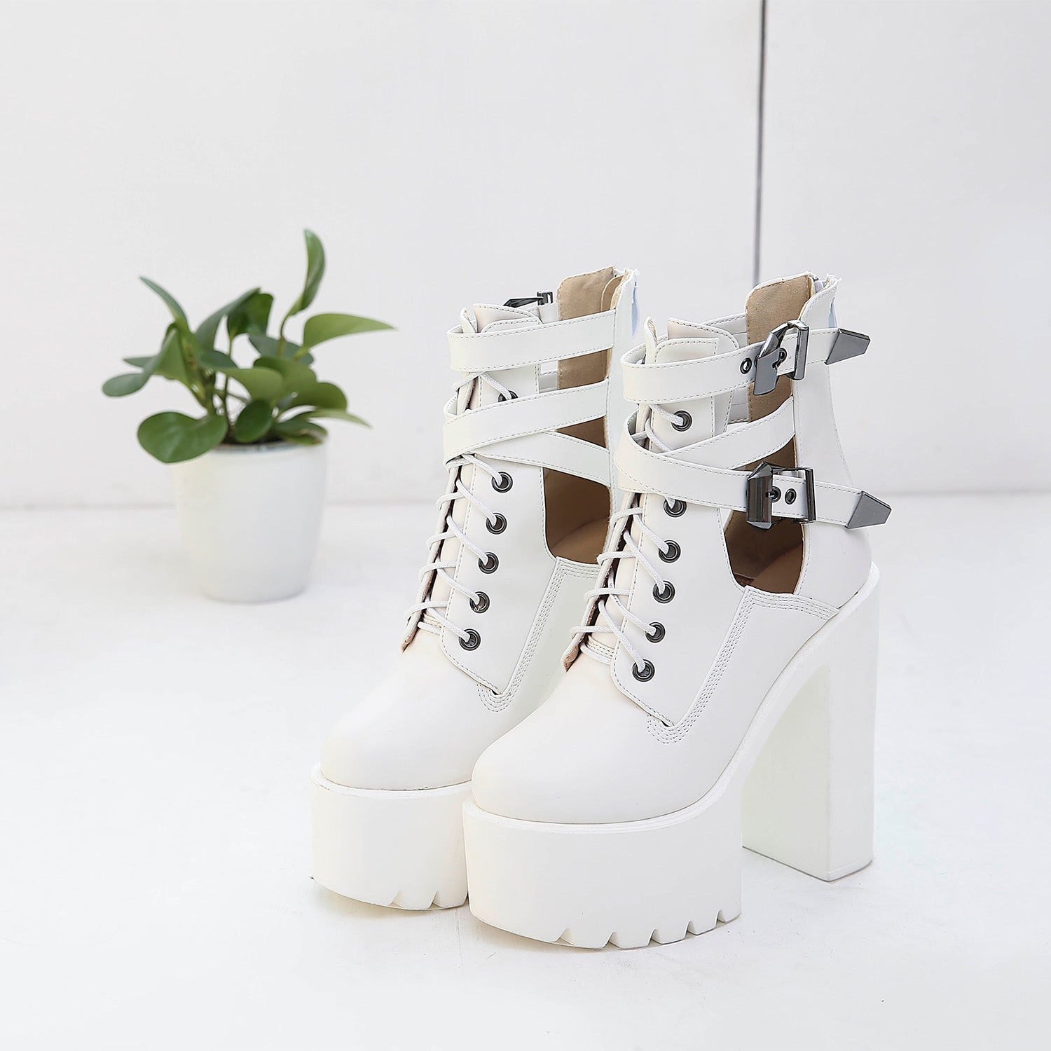 Trendy white chunky platform ankle boots with laces and metal buckles, perfect for rocker outfits.