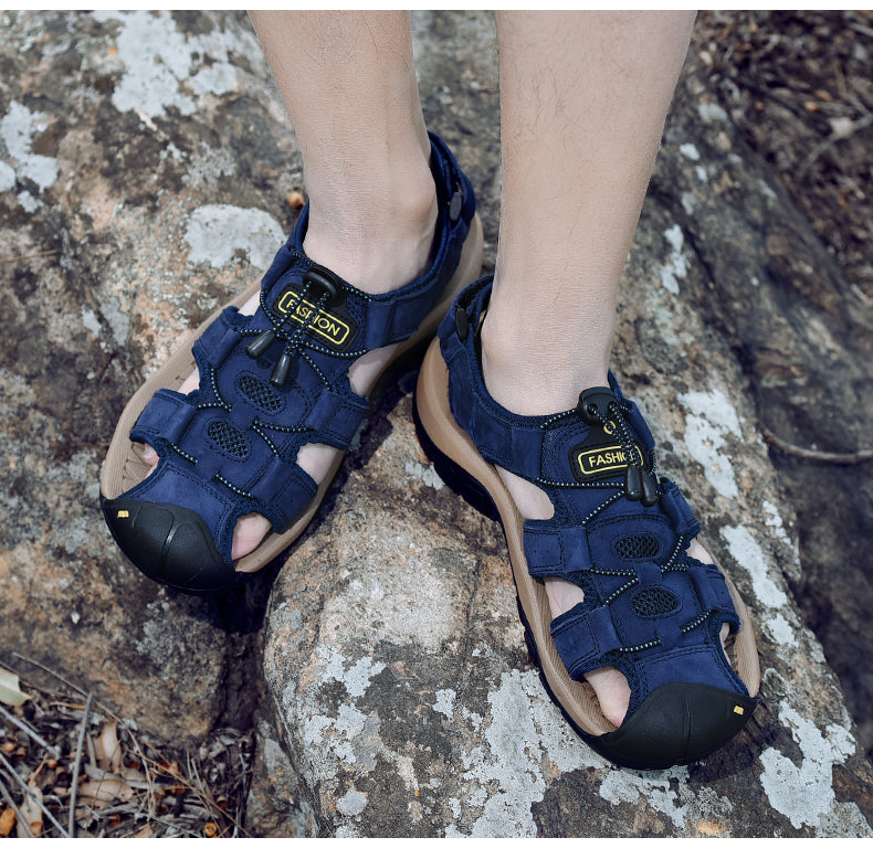 Navy blue male sandals on rocky surface, perfect for summer beach outings and alternative outdoor fashion.