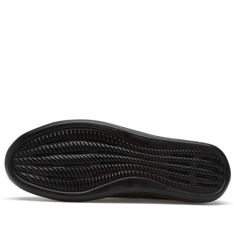 Bottom view of genuine leather mid-top men's sneakers, showcasing the textured outsole for grip and durability.