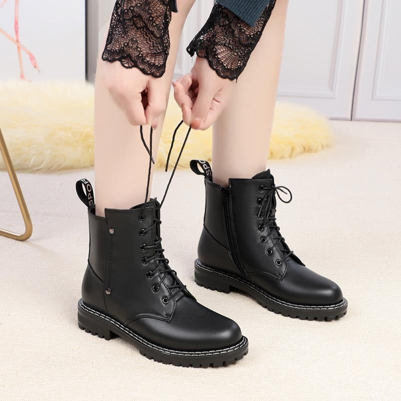 Stylish black genuine leather snow ankle boots for women, featuring chunky rubber soles and lace-up design.