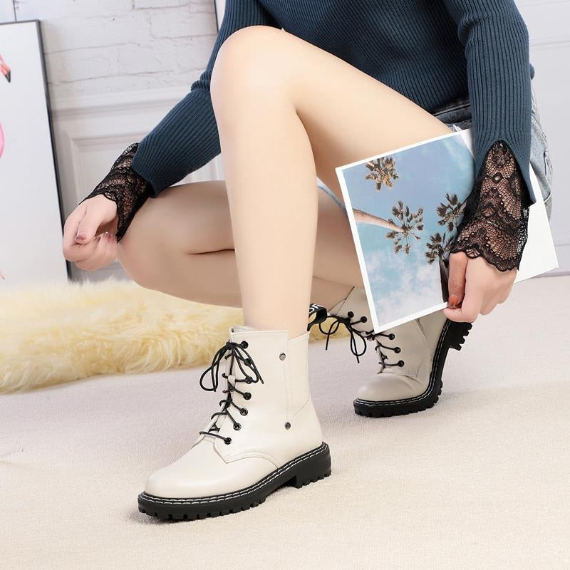 Stylish woman wearing genuine leather snow ankle boots, showcasing elegance with casual attire and a magazine.