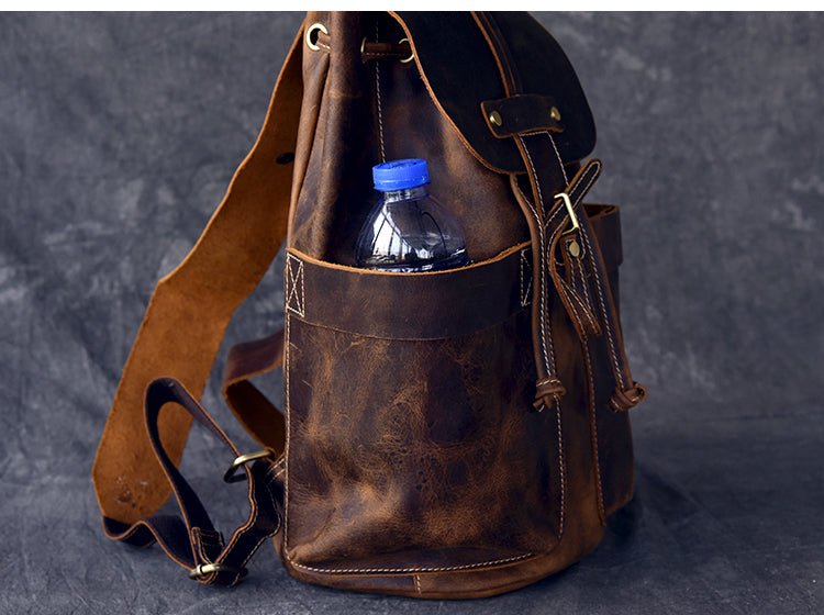 Genuine leather travel backpack featuring a front pocket with a water bottle, perfect for rock and steampunk fashion.
