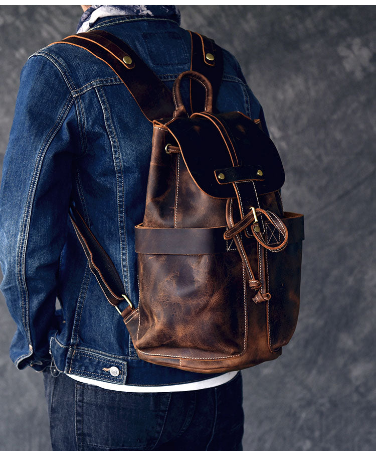 Genuine leather travel backpack in rock style worn by a person in a denim jacket, showcasing its chic design and pockets.