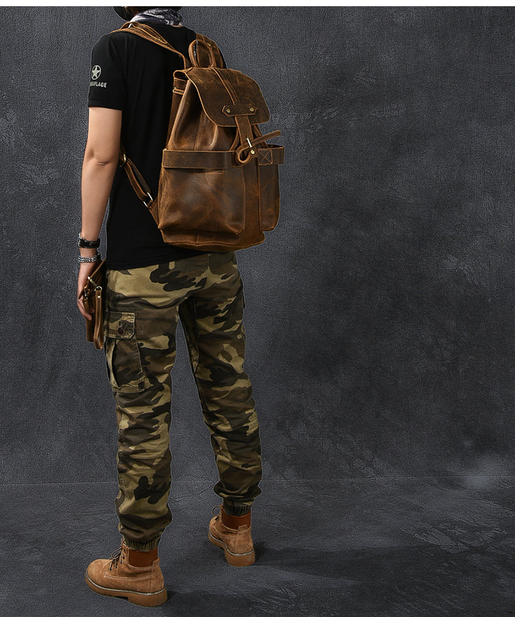 Rock-style genuine leather backpack displayed on a person wearing camo pants, perfect for steampunk and goth outfits.