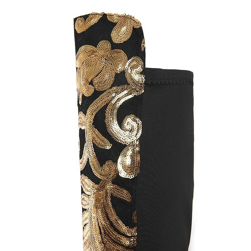 Close-up of black knee-high boot with sparkling golden sequins, showcasing its fashionable design and alternative style.