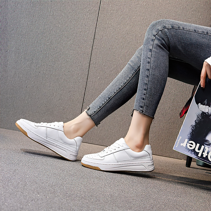 Genuine leather women's sneakers in white, perfect for spring or fall, paired with stylish jeans.