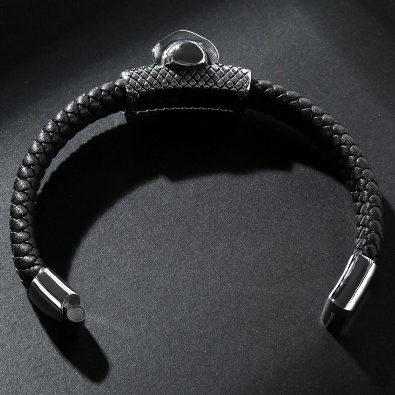 Stylish men's black leather bracelet with textured design and magnetic clasp on dark background.