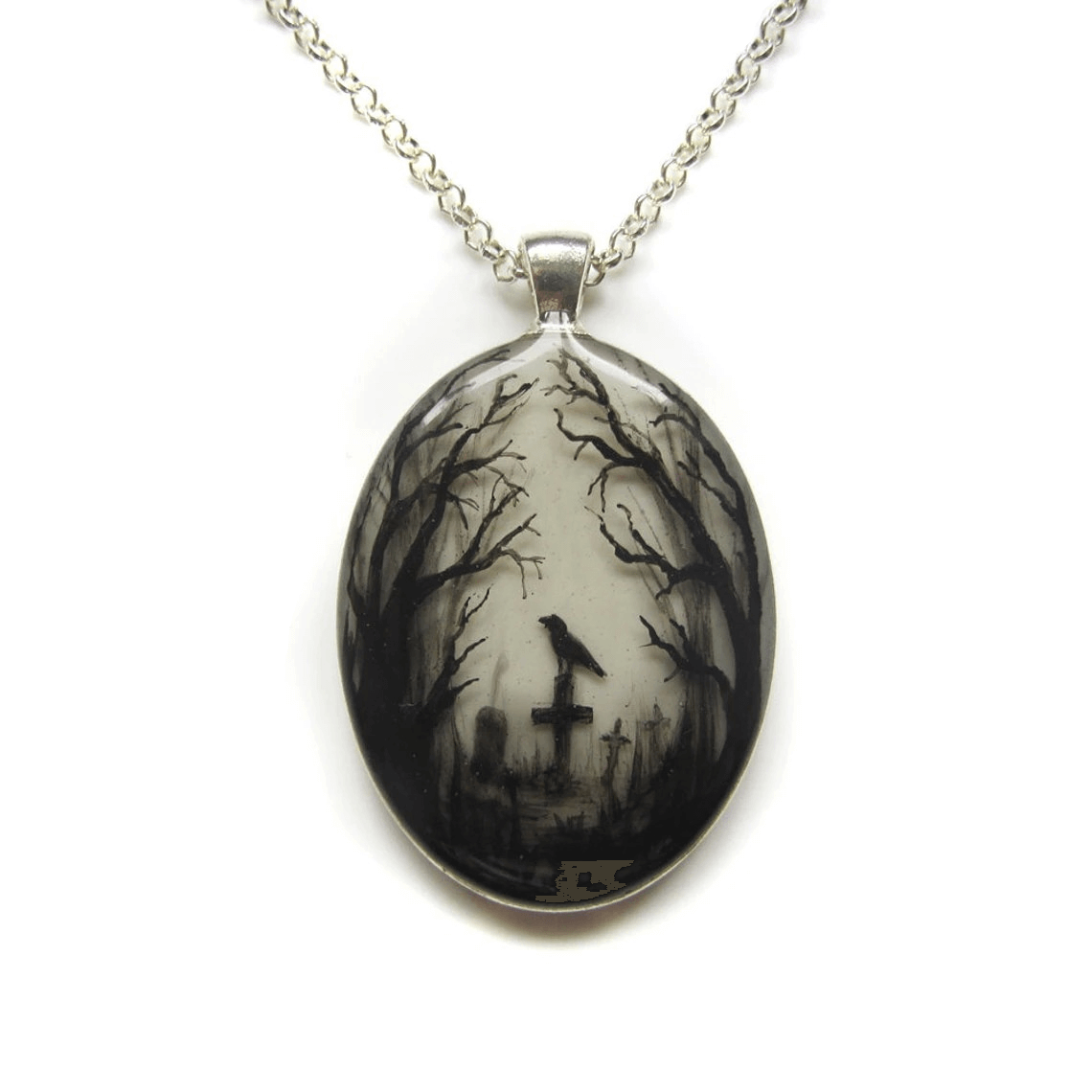 Gothic style oval pendant featuring a graveyard scene with a crow and bare trees, set on a delicate chain.