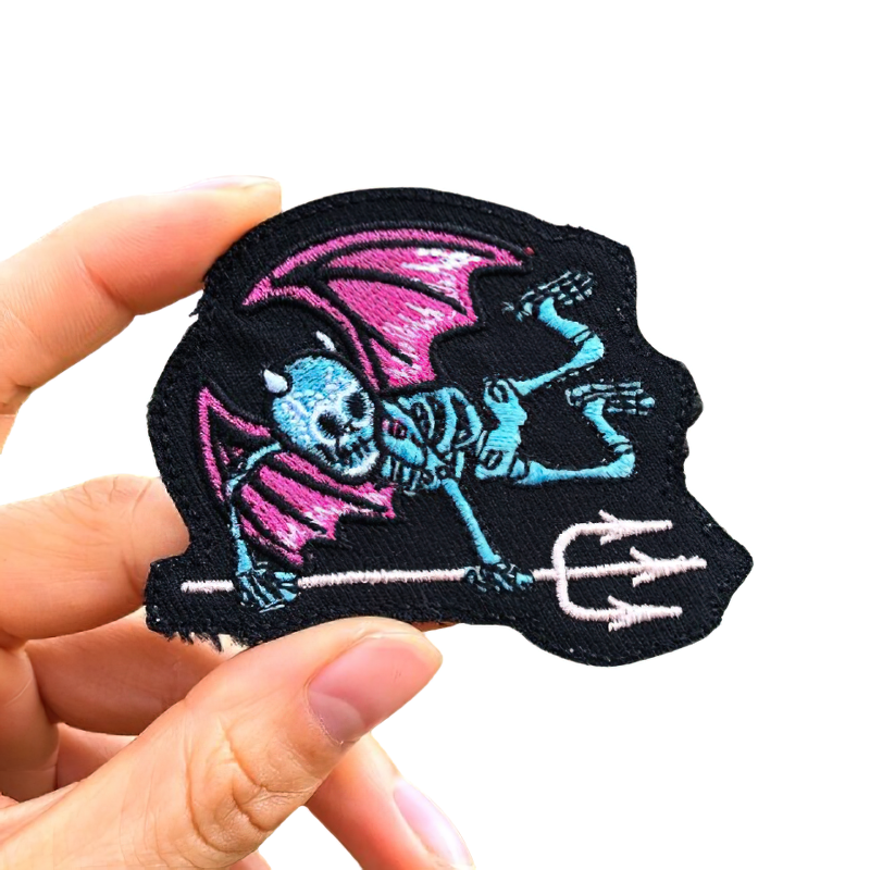Goth skeleton patch with wings and fork design, perfect for adding unique flair to clothes. Unisex rock style accessory.