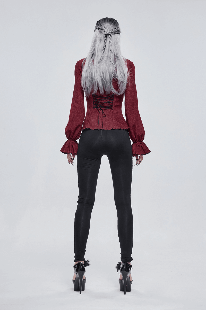 Back view of a woman in a gothic wine red blouse with flared sleeves, paired with black leggings and high heels.