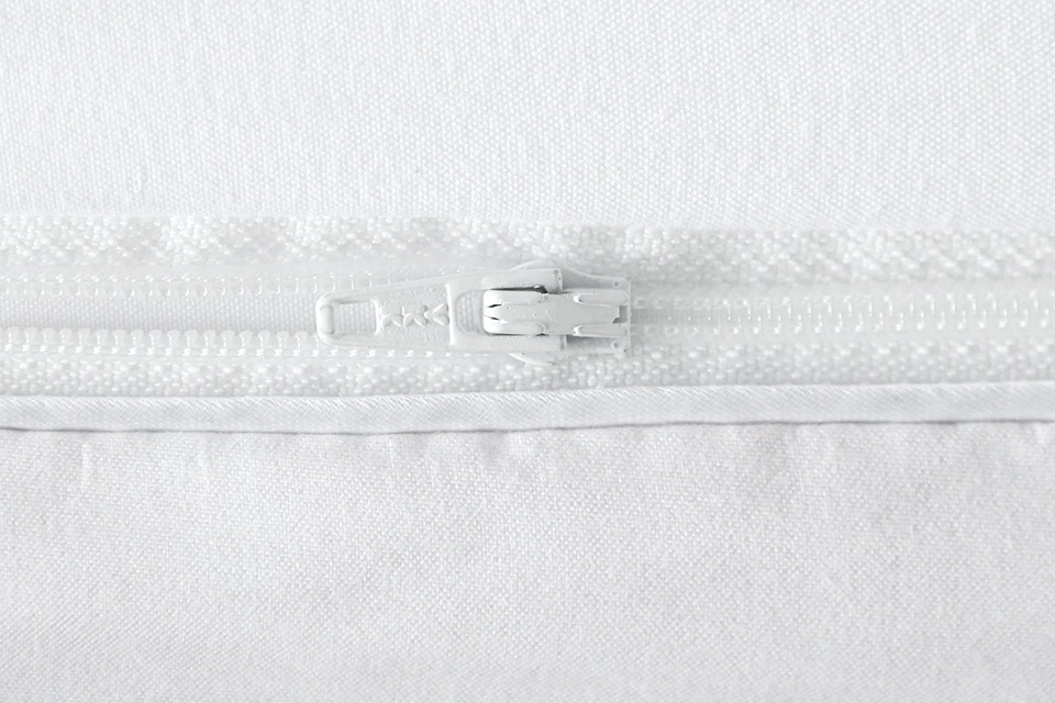Close-up of a white bedding zipper, showcasing quality craftsmanship and durability.